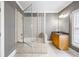 Bright bathroom with a large tub-shower combo with glass doors and a wood cabinet with granite countertop at 1363 Summer Lane Se Dr, Atlanta, GA 30316