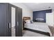 Neutral bedroom featuring a bed, mirrored wardrobe, a blue accent wall with artwork and neutral walls with crown molding at 1363 Summer Lane Se Dr, Atlanta, GA 30316