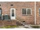 Backyard exterior featuring a brick wall, a door, window, and small stairwell at 2412 Peachwood Circle Northeast Ne Cir # 3, Atlanta, GA 30345