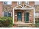 Close-up of a welcoming townhouse entrance with a covered porch and lush greenery at 2412 Peachwood Circle Northeast Ne Cir # 3, Atlanta, GA 30345