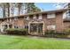Attractive brick townhouse featuring stone accents, a covered porch, and a well-kept lawn at 2412 Peachwood Circle Northeast Ne Cir # 3, Atlanta, GA 30345