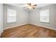 This bedroom features stylish wood flooring, a ceiling fan, and two large windows at 2485 Brentwood Rd, Decatur, GA 30032