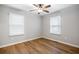 This bedroom features stylish wood flooring, a ceiling fan, and two large windows at 2485 Brentwood Rd, Decatur, GA 30032