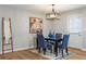 Dining area with a black table with blue chairs and a modern light fixture at 2485 Brentwood Rd, Decatur, GA 30032