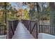 A private wooden bridge surrounded by lush greenery, offering a tranquil escape into nature at 3235 Roswell Ne Rd # 919, Atlanta, GA 30305