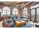 Living room with exposed brick, large windows, grey sofa, and colorful decor at 3235 Roswell Ne Rd # 919, Atlanta, GA 30305