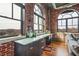 Living room area with exposed brick, large windows, hard wood floors, and built in desk with storage space at 3235 Roswell Ne Rd # 919, Atlanta, GA 30305