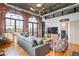 Charming living room with exposed brick, large windows, and cozy seating area at 3235 Roswell Ne Rd # 919, Atlanta, GA 30305
