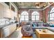 Open-concept living room with exposed brick, modern kitchen, and large windows at 3235 Roswell Ne Rd # 919, Atlanta, GA 30305