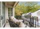 Relaxing balcony with seating area and wrought iron railing overlooking the backyard at 301 Abercorn Sq, Peachtree City, GA 30269