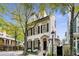 Three-story home with dark shutters, well-manicured yard, and mature trees at 301 Abercorn Sq, Peachtree City, GA 30269