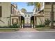 A black gate is surrounded by brick walls, greenery, and trees at 301 Abercorn Sq, Peachtree City, GA 30269