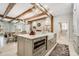 Spacious eat-in kitchen features an island, tile flooring, exposed beams, and modern appliances at 301 Abercorn Sq, Peachtree City, GA 30269