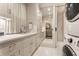 Laundry room with white cabinets, marble countertop, undermount sink, and modern washer and dryer at 301 Abercorn Sq, Peachtree City, GA 30269