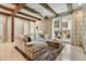 Bright living room features beamed ceilings, tile floors, and patio access for indoor-outdoor living at 301 Abercorn Sq, Peachtree City, GA 30269