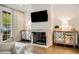 Cozy living room featuring a fireplace, hardwood floors, and mirrored cabinets at 301 Abercorn Sq, Peachtree City, GA 30269