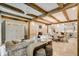 Open living space with beamed ceilings, tile floors, and access to kitchen, dining and outdoor spaces at 301 Abercorn Sq, Peachtree City, GA 30269