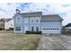 Two-story home with a blue facade, attached two-car garage and manicured front yard at 312 Jodeco Station E Cir, Stockbridge, GA 30281