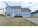 Two-story home with a blue facade, attached two-car garage and manicured front yard at 312 Jodeco Station E Cir, Stockbridge, GA 30281