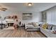 Living room featuring wood laminate flooring, large sectional sofa and ceiling fan at 312 Jodeco Station E Cir, Stockbridge, GA 30281