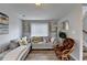 Corner of the living room showcasing a cozy chair and sectional sofa with wood laminate floors at 312 Jodeco Station E Cir, Stockbridge, GA 30281