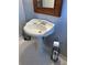 Pedestal sink with a decorative mirror and white tiled floor in this bathroom at 1255 North Nw Ave, Atlanta, GA 30318