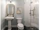 Bathroom features a pedestal sink, toilet and walk-in shower with glass door at 2261 Venetian Dr, Atlanta, GA 30311