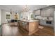 Modern kitchen boasts gray cabinets, stainless steel appliances, island with seating, and hardwood floors at 2261 Venetian Dr, Atlanta, GA 30311