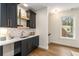 Stylish wet bar area with dark cabinets, a white countertop, and a window with a view of the neighborhood at 2261 Venetian Dr, Atlanta, GA 30311