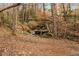 A natural stream with exposed rocks flows through the forested park and walking trail at 2261 Venetian Dr, Atlanta, GA 30311