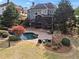 Aerial view of the home's backyard showcasing the patio, outdoor fireplace, pool, and lush landscaping at 410 Hickory Fairway Ct, Woodstock, GA 30188
