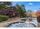 Landscaped backyard with pool, hot tub, outdoor seating, fireplace, patio and staircase to upper deck at 410 Hickory Fairway Ct, Woodstock, GA 30188