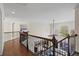 View of upper landing with hardwood floors, iron railing, and staircase overlooking the living area at 410 Hickory Fairway Ct, Woodstock, GA 30188
