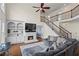 Bright living room with fireplace, built-in shelving, and elegant staircase with iron railing at 410 Hickory Fairway Ct, Woodstock, GA 30188