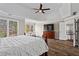 Spacious main bedroom with tray ceiling, hardwood floors, large windows, and a staircase at 410 Hickory Fairway Ct, Woodstock, GA 30188