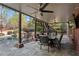 Covered outdoor patio with stone floor, dining table, ceiling fans, and a relaxing view of the pool and backyard at 410 Hickory Fairway Ct, Woodstock, GA 30188