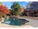 Gorgeous backyard pool area with stone waterfall features, lush landscaping, and a spacious patio with stairs at 410 Hickory Fairway Ct, Woodstock, GA 30188