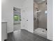 Modern bathroom with glass shower and gray tile floor, next to the main bedroom at 201 Retreat Ln, Canton, GA 30114