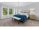 Bedroom boasts a beautiful chandelier, a plush carpet, a king bed, and serene views from its many windows at 201 Retreat Ln, Canton, GA 30114
