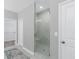 Modern bathroom shower with elegant white marble tile and a glass door at 201 Retreat Ln, Canton, GA 30114