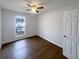 Comfortable bedroom featuring hardwood floors, a ceiling fan, and a window at 2043 Grove Way, Hampton, GA 30228