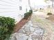 Side yard view with stone path, mature shrubs and landscaping at 735 Sunset Ridge Ln, Lawrenceville, GA 30045