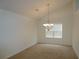 Bright dining room with plush carpet, a classic chandelier, and abundant natural light at 735 Sunset Ridge Ln, Lawrenceville, GA 30045