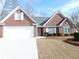 Well-maintained brick home with a two-car garage and landscaped front yard at 735 Sunset Ridge Ln, Lawrenceville, GA 30045