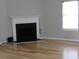 Cozy living room with a classic fireplace, hardwood floors, and a large window providing natural light at 4423 Gladewood Run, Union City, GA 30291