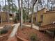 Condos with wood siding nestled among tall trees and pedestrian walkways at 5820 Par Four Ct, Lithonia, GA 30038