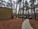 Parking area behind condo units among tall trees at 5820 Par Four Ct, Lithonia, GA 30038