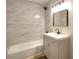 Bathroom featuring modern vanity, updated fixtures, and tiled shower with tub at 127 Holly St, Social Circle, GA 30025