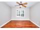 Bedroom with hardwood floors and a ceiling fan receiving natural light from a large window at 127 Holly St, Social Circle, GA 30025