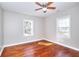 Bedroom with hardwood floors, ceiling fan, and two windows providing natural light at 127 Holly St, Social Circle, GA 30025